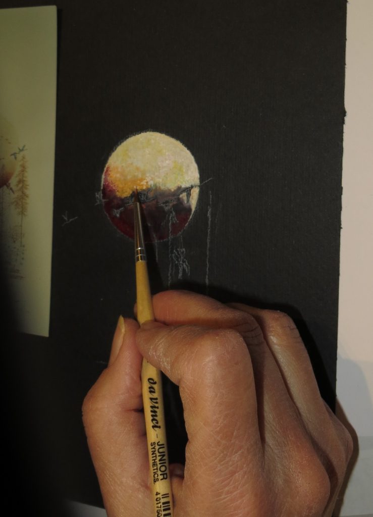 Main et miniature sur fond noir